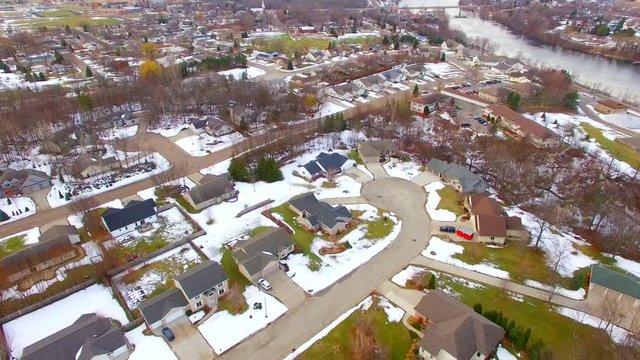 Aerial view of small town USA, neighborhoods, scenic river, springtime. One side of the river is muddy with runoff from a stream just upriver, very interesting to see from above.