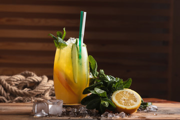 Concept: restaurant menus, healthy eating, homemade, gourmands, gluttony. Handmade lemonade with ingredients on messy vintage weathered wooden background.