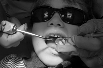 Obraz premium Child patient having her teeth examined by specialist dentist