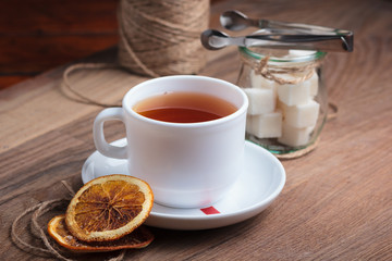 Concept: restaurant menus, healthy eating, homemade, gourmands, gluttony. Tea in white cup with sweets on weathered wooden background.