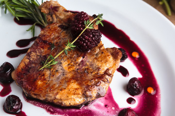 Concept: restaurant menus, healthy eating, homemade, gourmands, gluttony. Pork steak on the bone with cherry-ginger sauce with ingredients on messy sackcloth background.