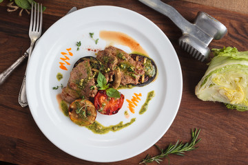 Concept: restaurant menus, healthy eating, homemade, gourmands, gluttony. White plate of veal medallions with grilled vegetables and 