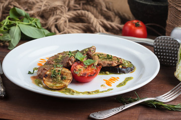 Concept: restaurant menus, healthy eating, homemade, gourmands, gluttony. White plate of veal medallions with grilled vegetables and 