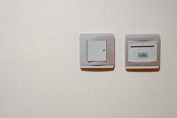 Gray modern light switch lock and electronic key card slot with fabric texture wall background. button turned on. Copy space.