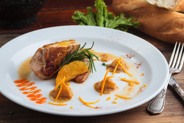 Concept: restaurant menus, healthy eating, homemade, gourmands, gluttony. White plate of chicken breast stuffed with orange brazilian way on vintage weathered wooden table.