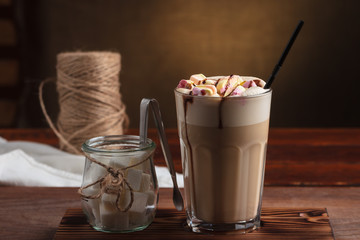 Concept: restaurant menus, healthy eating, homemade, gourmands, gluttony. Hot latte with marshmallows with sugar on vintage wooden table.