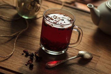 Concept: restaurant menus, healthy eating, homemade, gourmands, gluttony. Hibiscus tea with fruit pieces and sugar in glass jar on vintage wooden background.