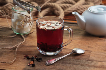 Concept: restaurant menus, healthy eating, homemade, gourmands, gluttony. Hibiscus tea with fruit pieces and sugar in glass jar on vintage wooden background.