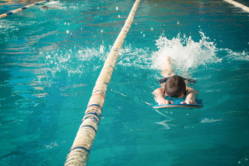 Little boy swimming in pool.