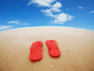 Fototapeta na wymiar Red flip flops on the beach