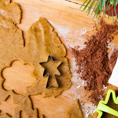 Cookies forms and gingerbread dough on wooden pastry board