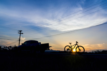 Silhouette Pickup truck with bicycle at sunset sky