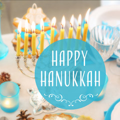 Menorah with candles on table served for Hanukkah celebration. Text HAPPY HANUKKAH © Africa Studio