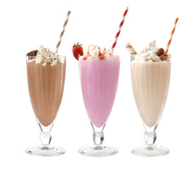 Glasses with delicious milk shakes on white background.