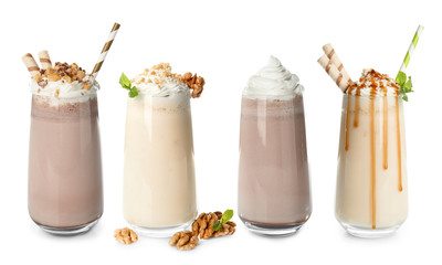 Glasses with delicious milk shakes on white background.
