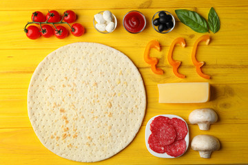 Raw pizza ingredients on wooden background, top view