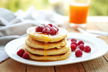 Stack of fresh pancakes with berries on white plate closeup