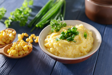 Tasty breakfast of cornmeal porridge with parsley and green onion, closeup