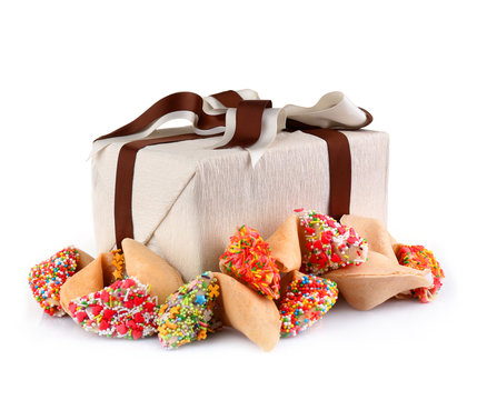 Pile of fortune cookies with sprinkles and present box isolated on white