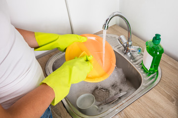 Close-up Of Person Washing Plate