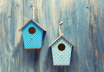 two birdhouses on antique rustic wood background.