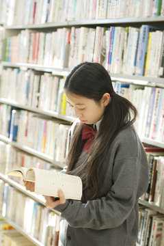 図書館で本を読む中学生