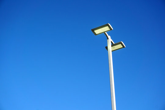 LED street lamp against blue sky