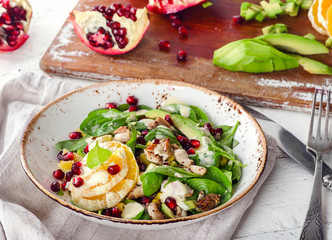 Salad with chicken, orange, spinach and pomegranate seeds.