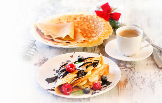 Christmas breakfast. Cup of Coffee and Crepes with fresh berries