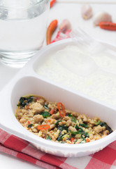 Rice topped with stir fried minced pork and basil on wood