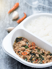 Rice topped with stir fried minced pork and basil on wood