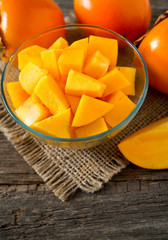 cut persimmon on wooden surface