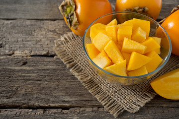 cut persimmon on wooden surface