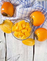 cut persimmon on wooden surface