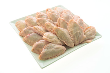 Raw chicken meat and wing in white plate
