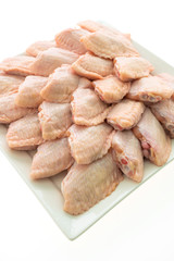 Raw chicken meat and wing in white plate