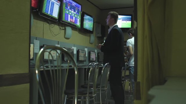 Man in suite bets on sports betting after hard work day