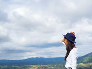 Back view of trendy girl in stylish with beautiful hat enjoying journey in mountains.