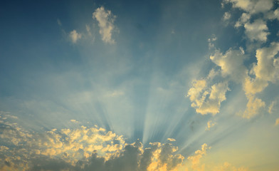 Fototapeta premium Promienie słoneczne świecą przez chmury.