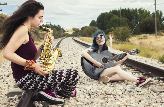 Dos mujeres tocando instrumentos en la vía del tren