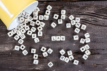 Word LAW on old wooden table.
