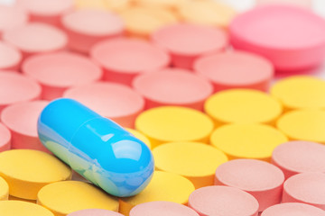 blue pill on orange, yellow medical tablets