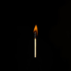 one burning match on a black background
