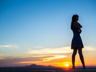 Silhouette of free woman enjoying freedom feeling happy at sunset. relaxing woman in pure happiness
