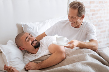 Cheerful homosexual aged man care about his partner