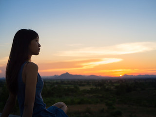 Silhouette of free woman enjoying freedom feeling happy at sunset. relaxing woman in pure happiness