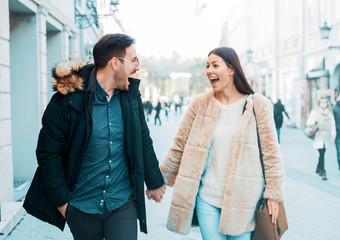 Beautiful smiling couple on dating walking down the street. Love