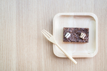 Dark chocolate brownies on wooden background.