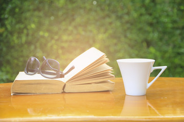 Stock Photo:.Coffee cup and book on table in the garden