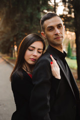 Young couple holding hands, smile and walk in the park in one au